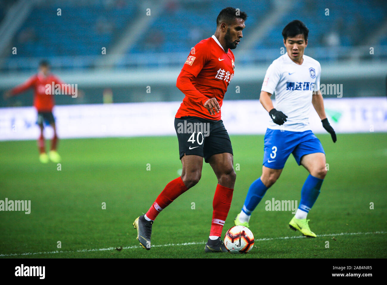 Brazilian-born Portuguese football player Dyego Sousa of Shenzhen F.C., left, keeps the ball during the 28th round match of Chinese Football Association Super League (CSL) against Tianjin TEDA in Tianjin, China, 23 November 2019. Tianjin TEDA slashed Shenzhen F.C. with 3-0. Stock Photo