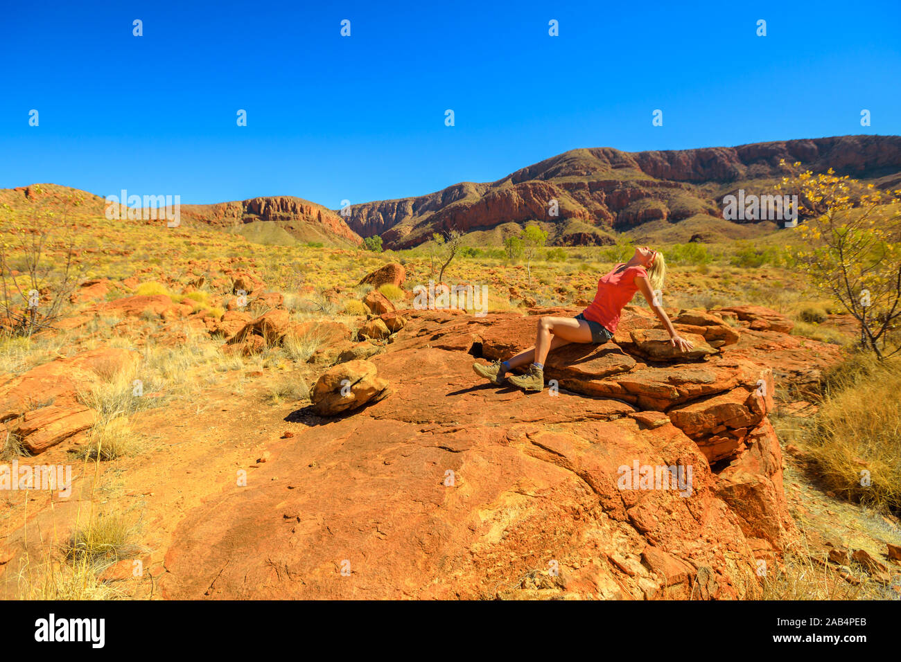 Tourist woman resting after hiking in Larapinta Trail section of Ormiston Pound Walk. West MacDonnell Ranges National Park in Northern Territory Stock Photo