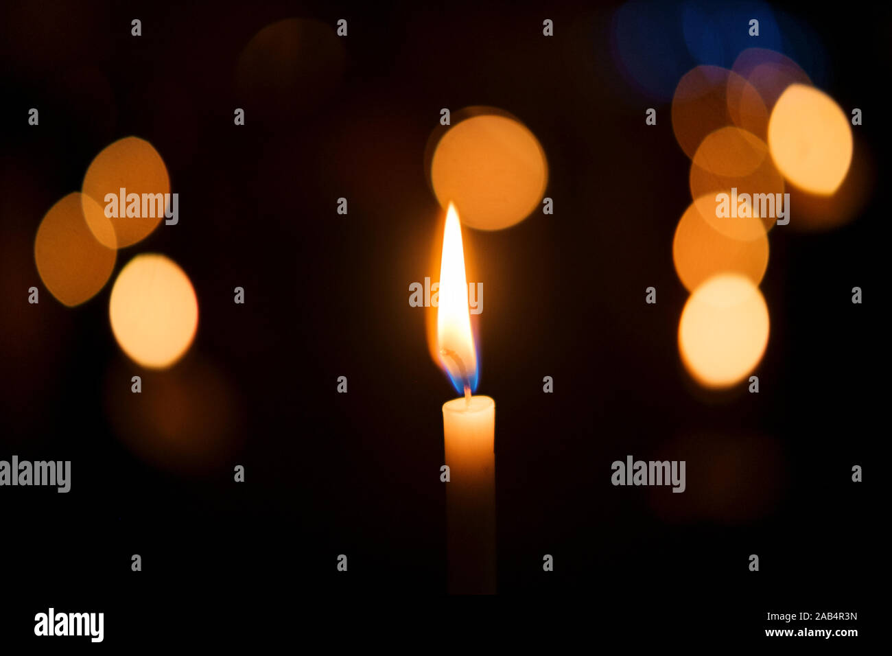 A candle in focus against a background of other candles out of focus at