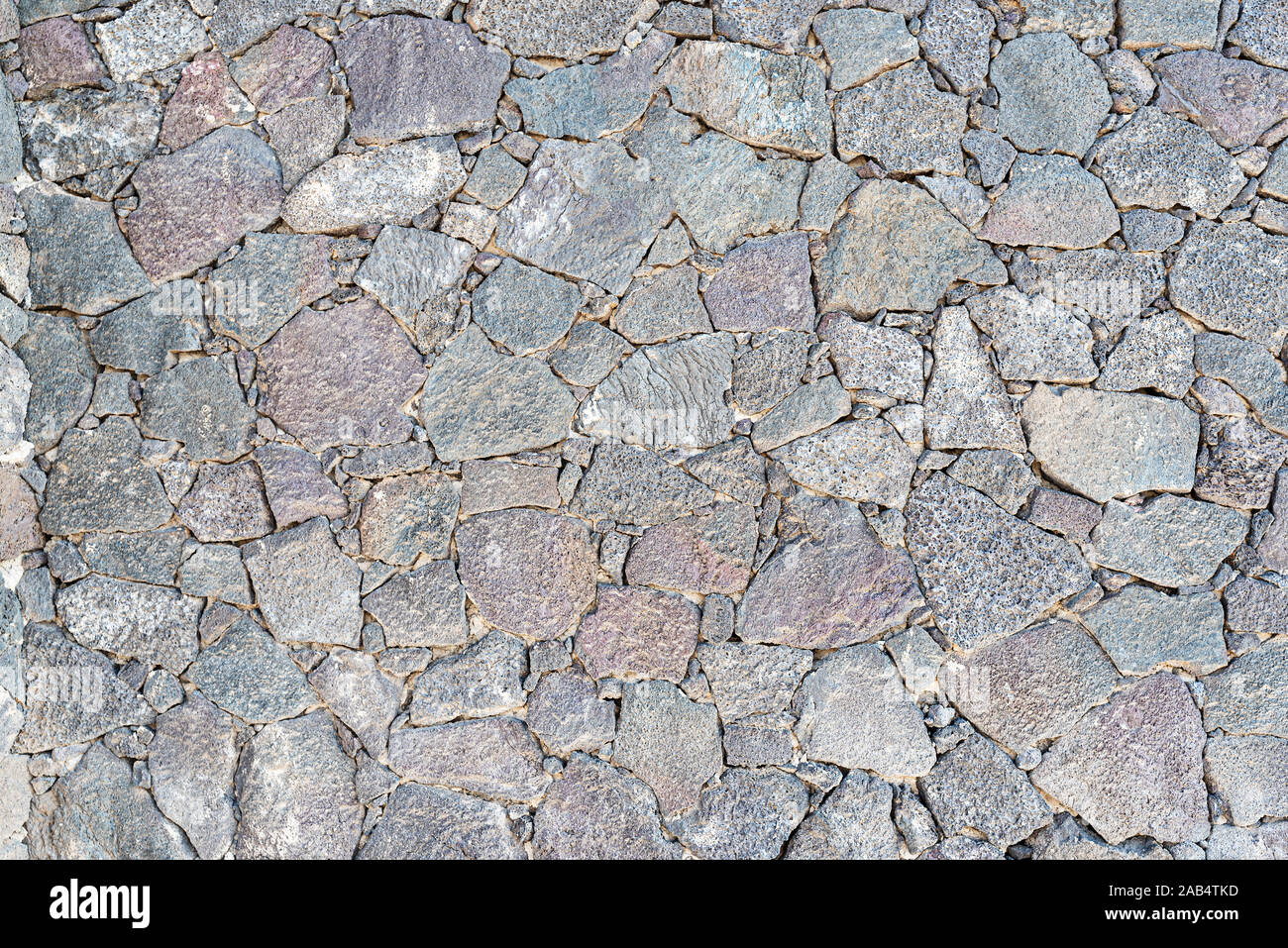 full-frame close-up of uneven dry stone wall background Stock Photo