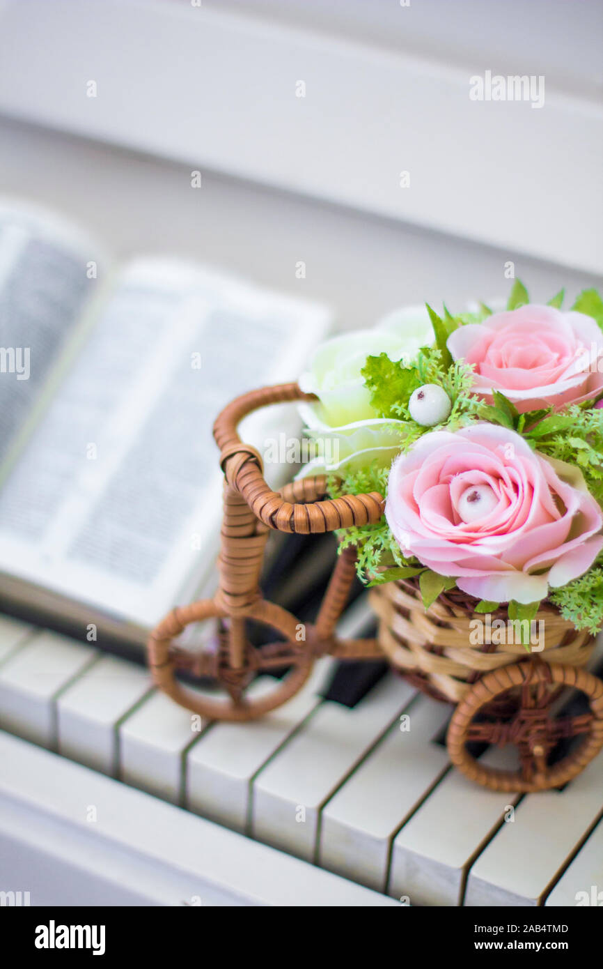 Decorative Flowers Roses In A Wicker Bicycle On The Piano And