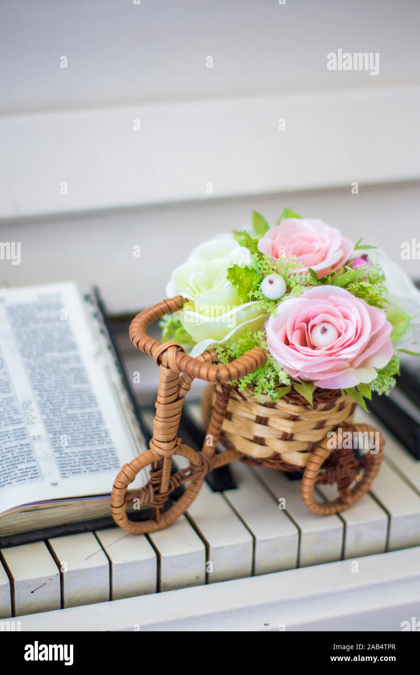 Decorative Flowers Roses In A Wicker Bicycle On The Piano And