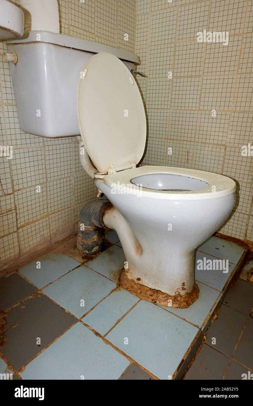 Defective old toilet and broken tiles Stock Photo