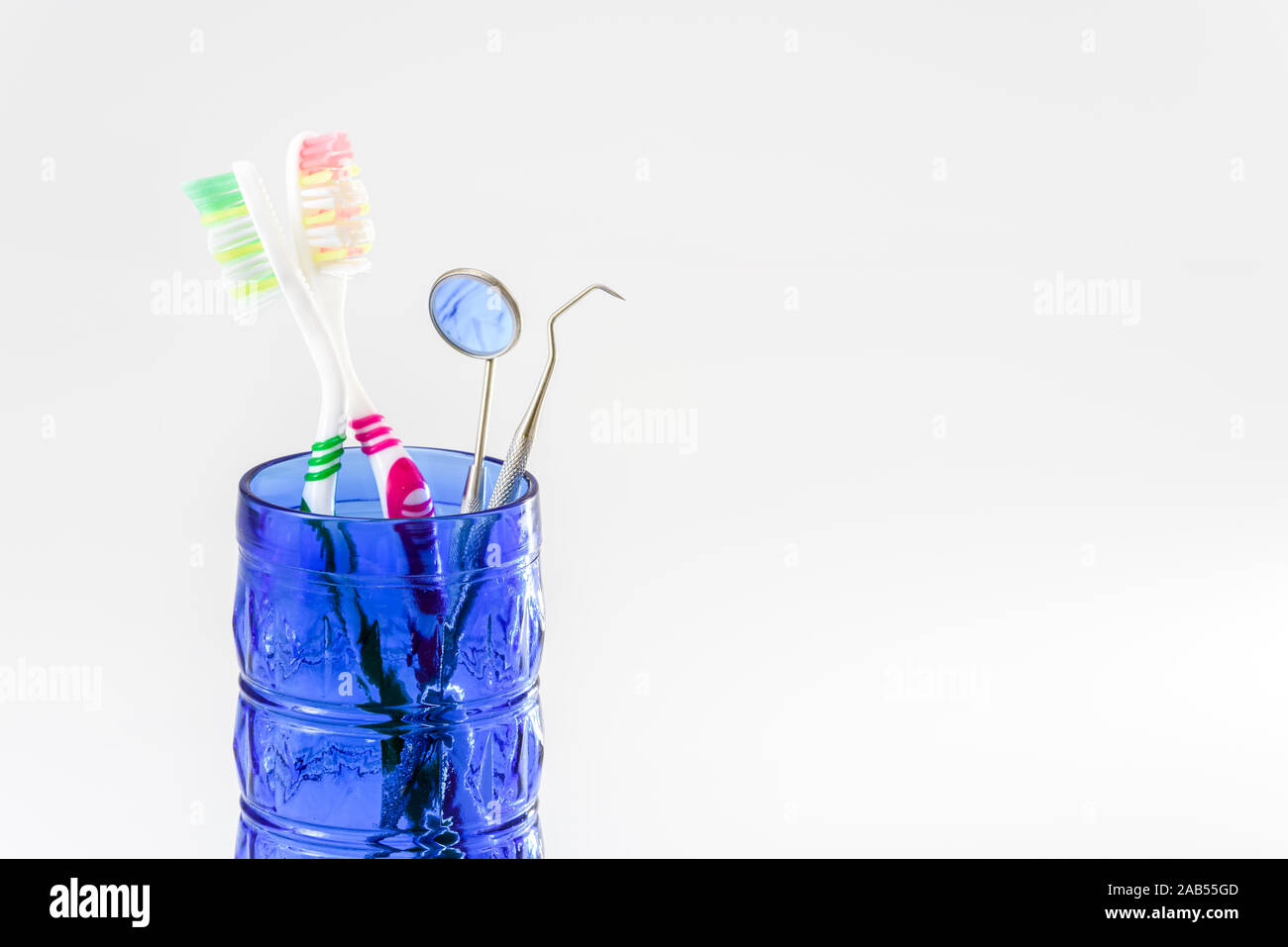 Toothbrushes in a glass and dental care set isolated on white ...