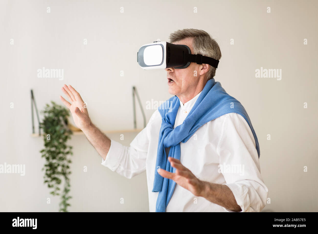 Excited senior man using VR glasses, having fun Stock Photo