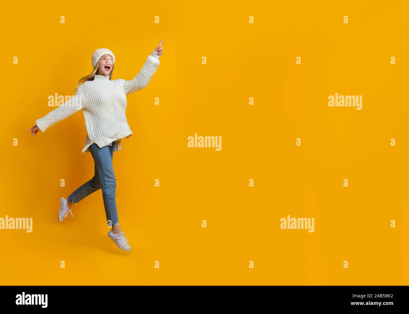 Excited winter girl running towards copy space Stock Photo