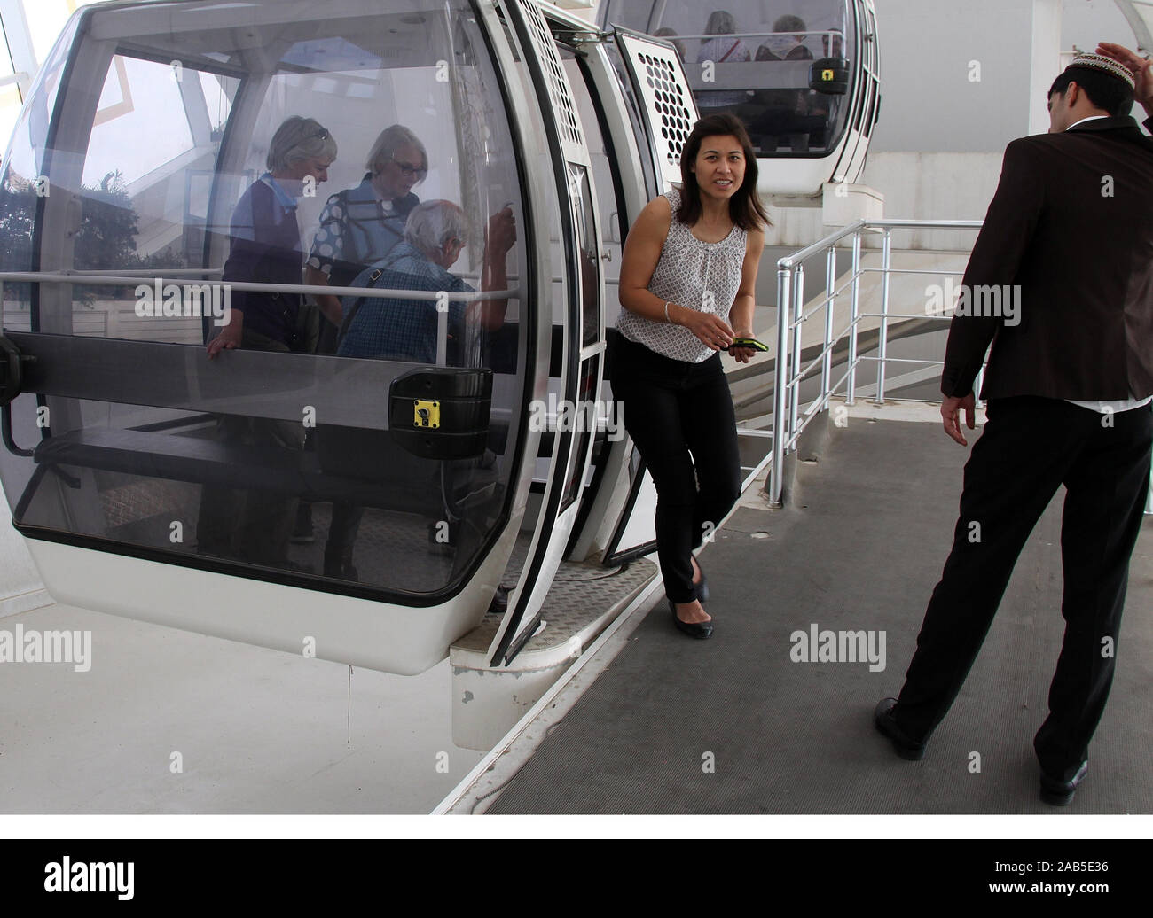 Tourists getting out of a gondola at the Alem ferris wheel in Ashgabat Stock Photo