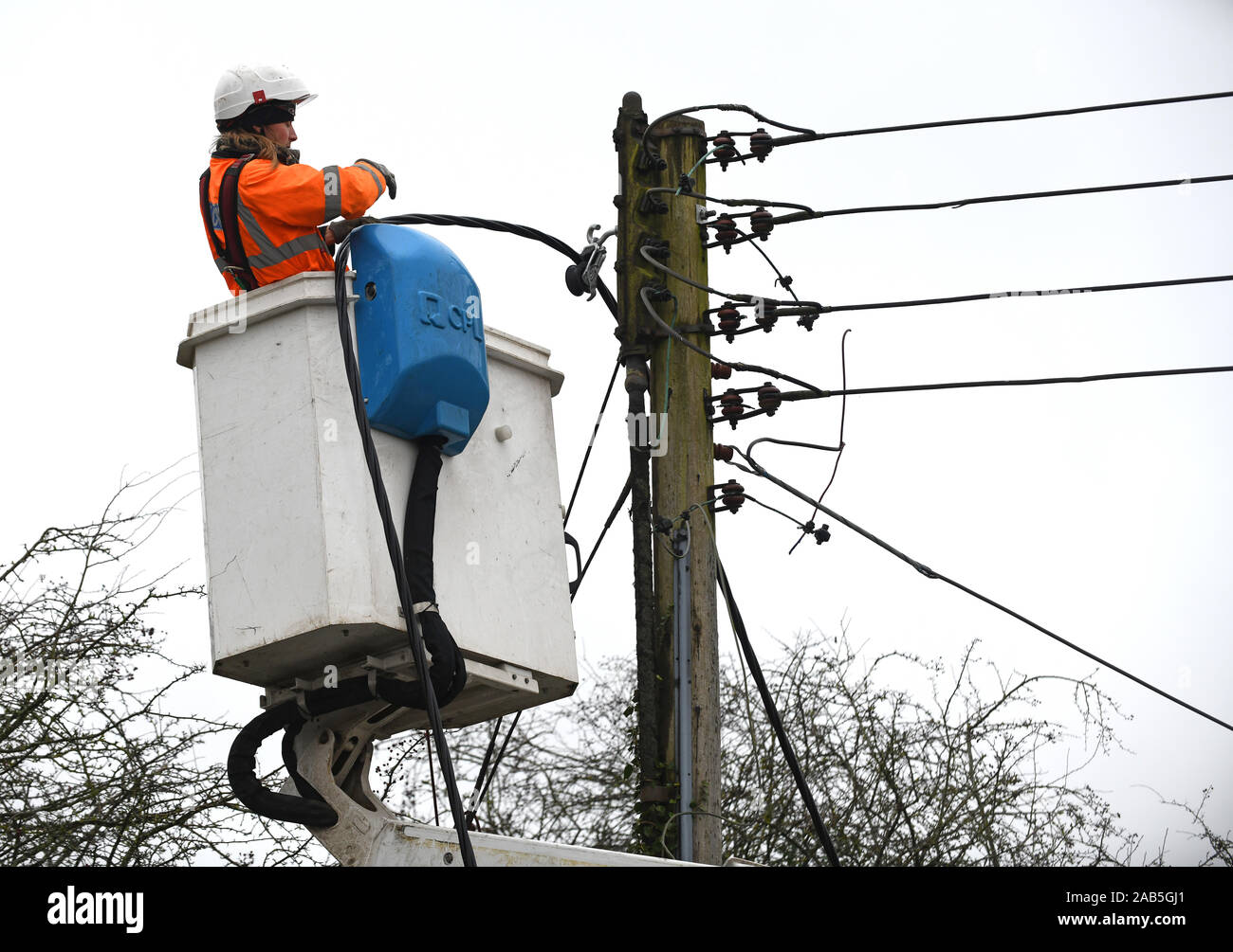 Electrician replacing mains overhead electricity cables for Western Power Distribution the electricity distribution network operator Stock Photo