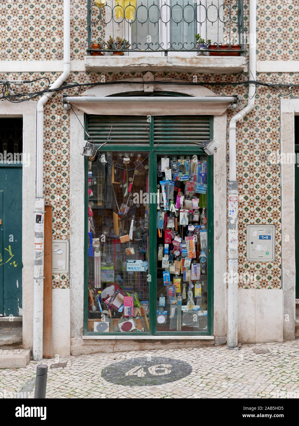 Glazed double doors to a shopfront in Lisbon, Portugal with things hanging in the window Stock Photo