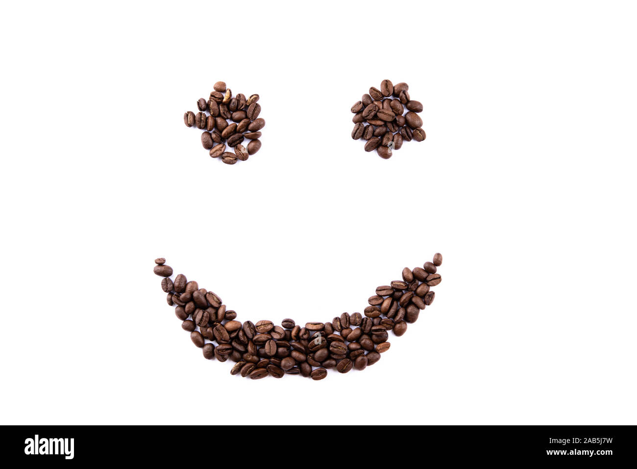 Smiley face made of coffee beans on white backgroud with copyspace Stock Photo