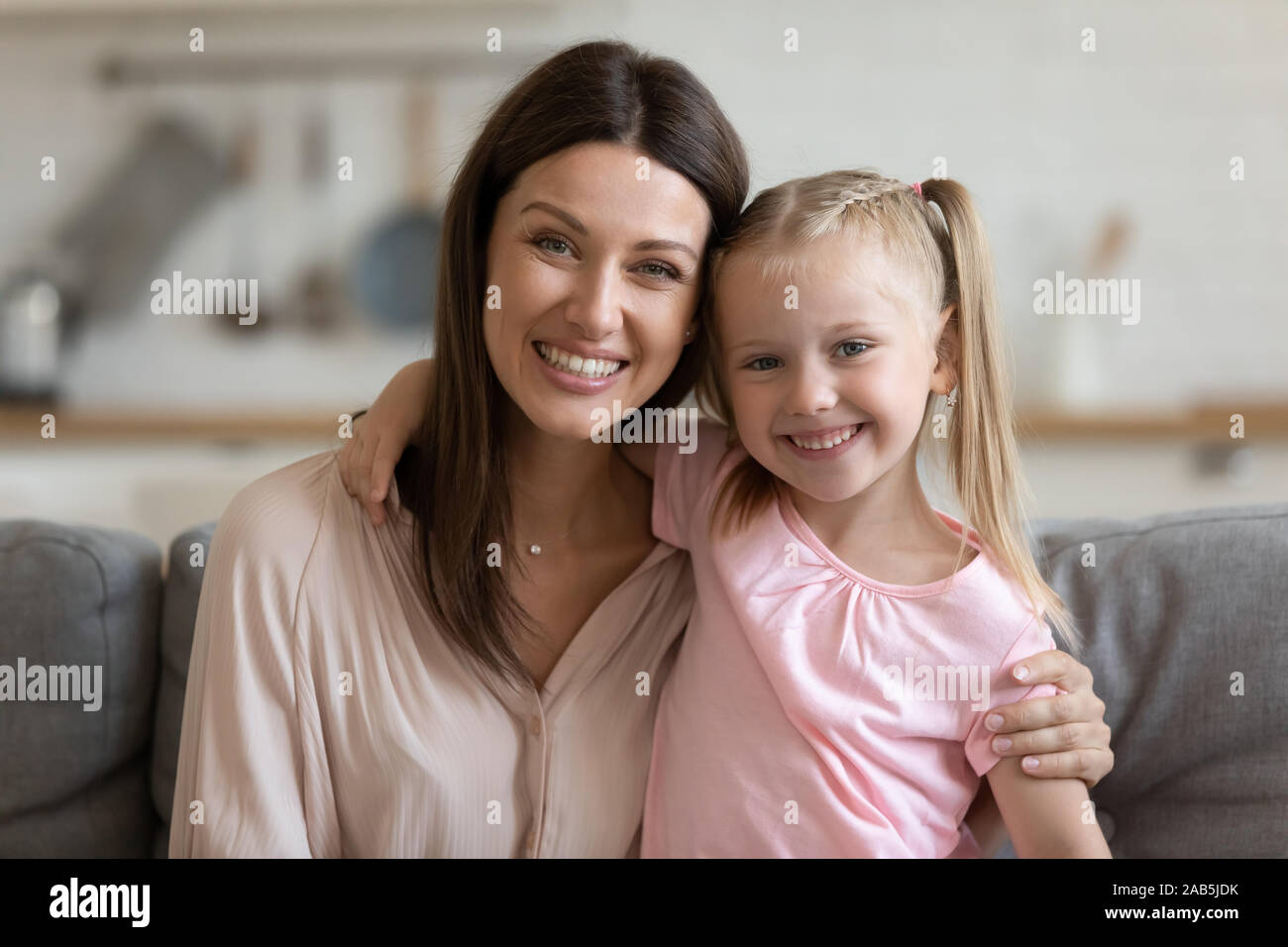 Affectionate single mom and child daughter embracing looking at camera Stock Photo