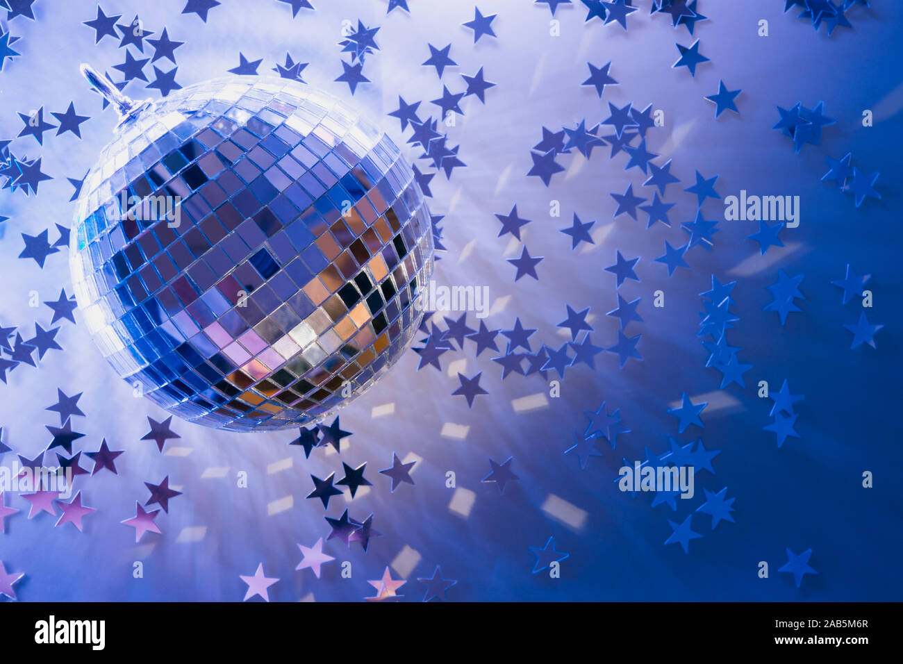 Christmas disco ball with rays on neon blue. Creative party background