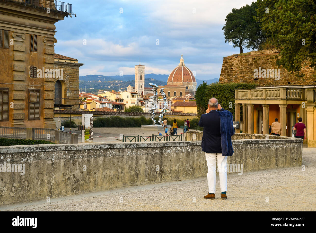 Tourist gentleman taking photos of the historic centre of Florence, Unesco World Heritage Site, from Boboli Gardens of Palazzo Pitti, Tuscany, Italy Stock Photo