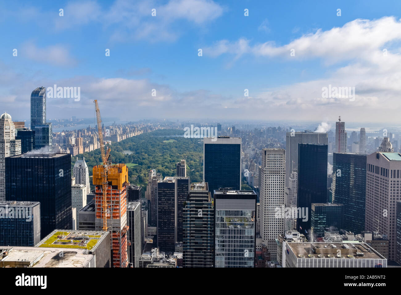 Aerial view of New York with skyscrapers, buildings in construction and central park in the background. Sunny day with some clouds. Concept of travel Stock Photo