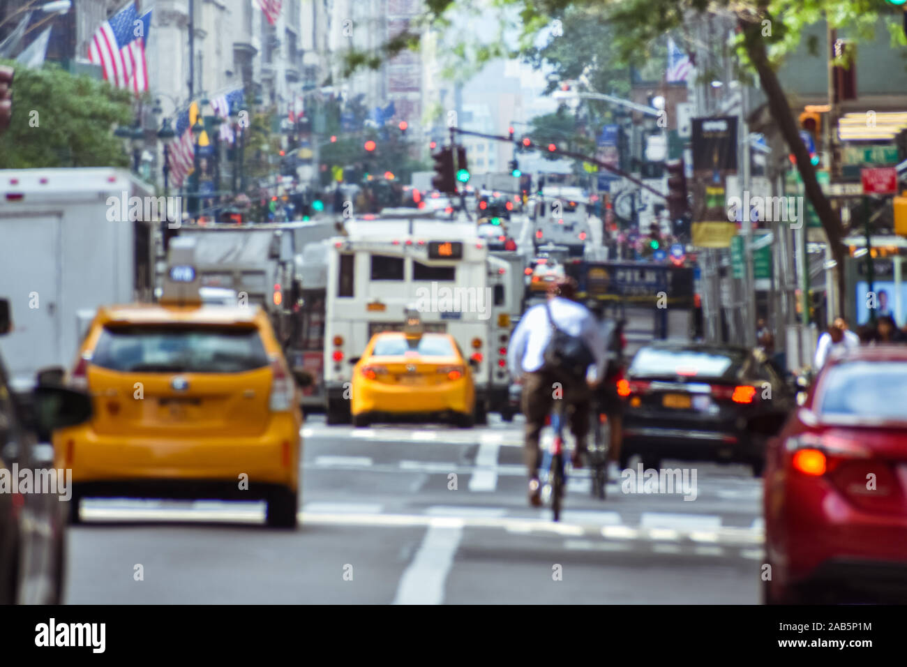 Blurred concept of the frenetic activity of life in New York. Cars, public transportation, bicyclists, pedestrians, buildings, signs and flags. Concep Stock Photo