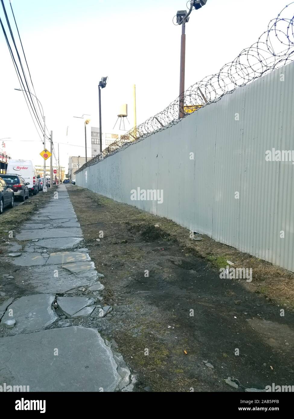 View of a crumbling sidewalk and barbed wire fencing along 10th Street in Long Island City, Queens, New York, March 11, 2019. () Stock Photo