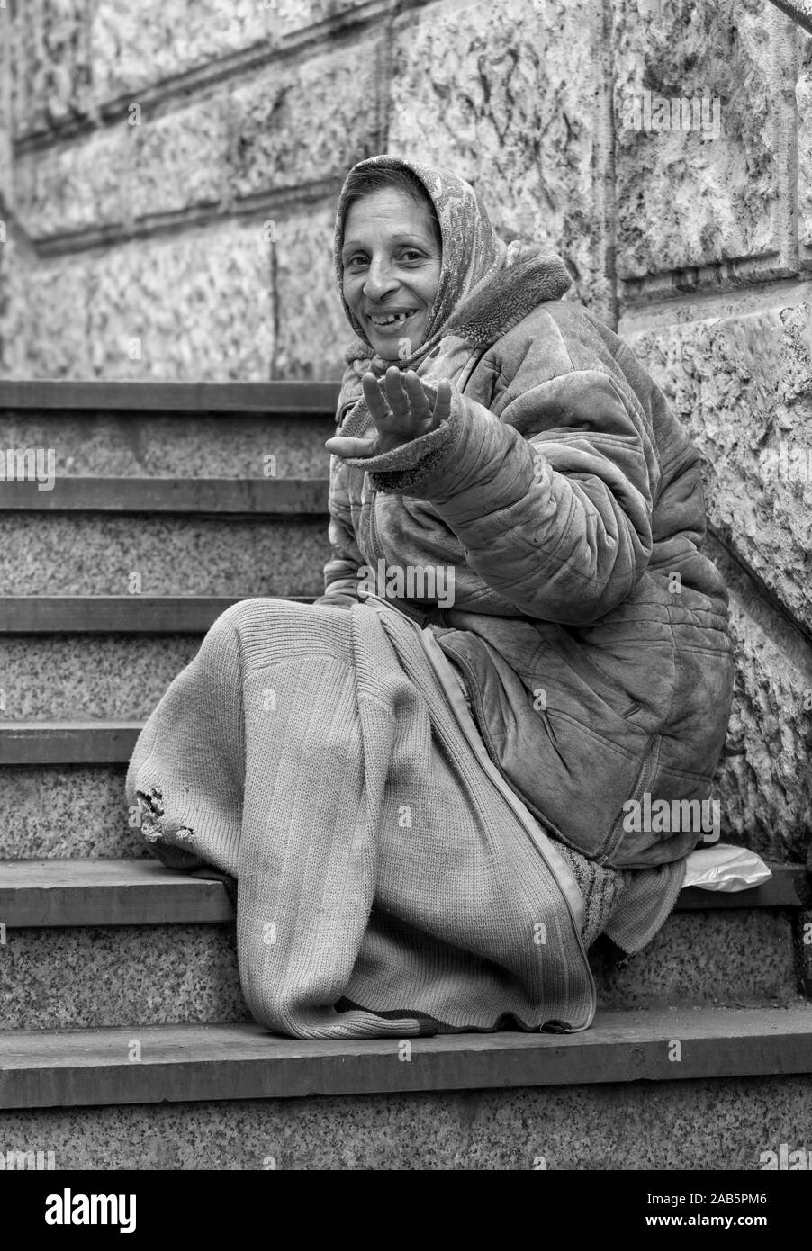 Smiling older lady begging on the street, Rome, Italy Stock Photo