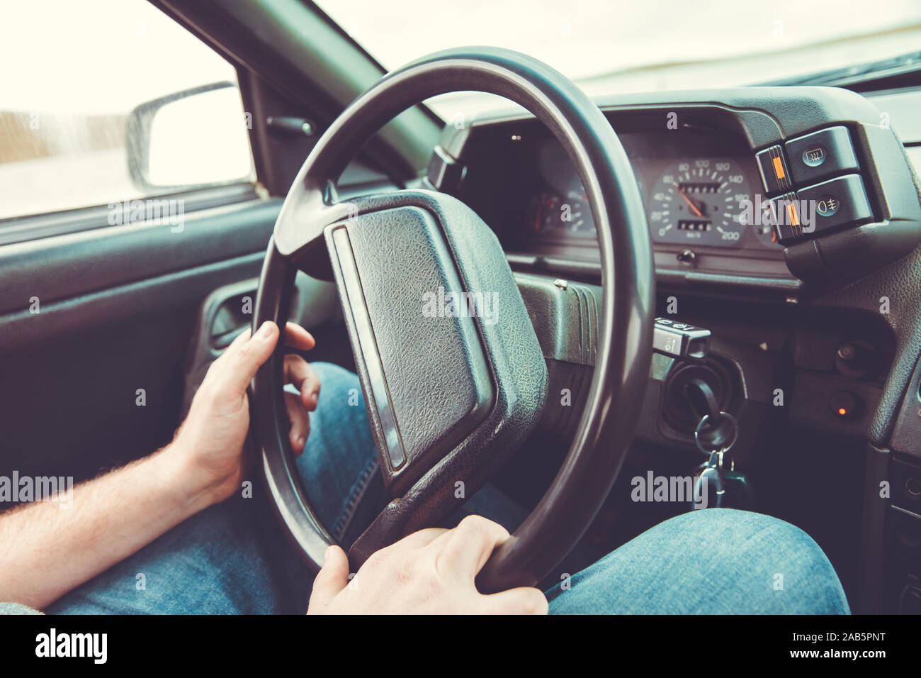 Car Interior. Male arms holding leathern rudder of car .the man grabs