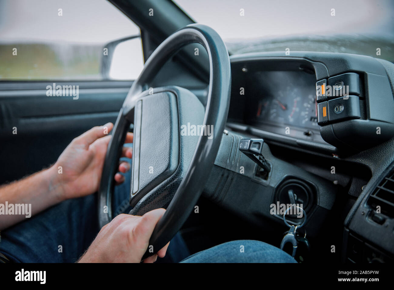 Car Interior. Male arms holding leathern rudder of car .the man grabs ...