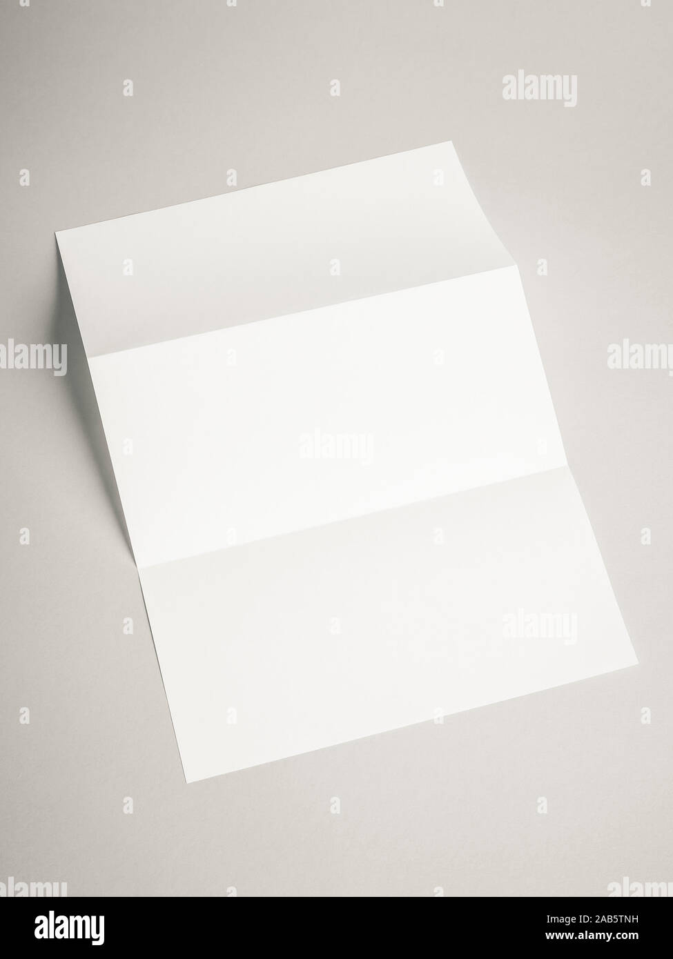 Ein Stueck gefaltetes Papier auf weissem Hintergrund Stock Photo