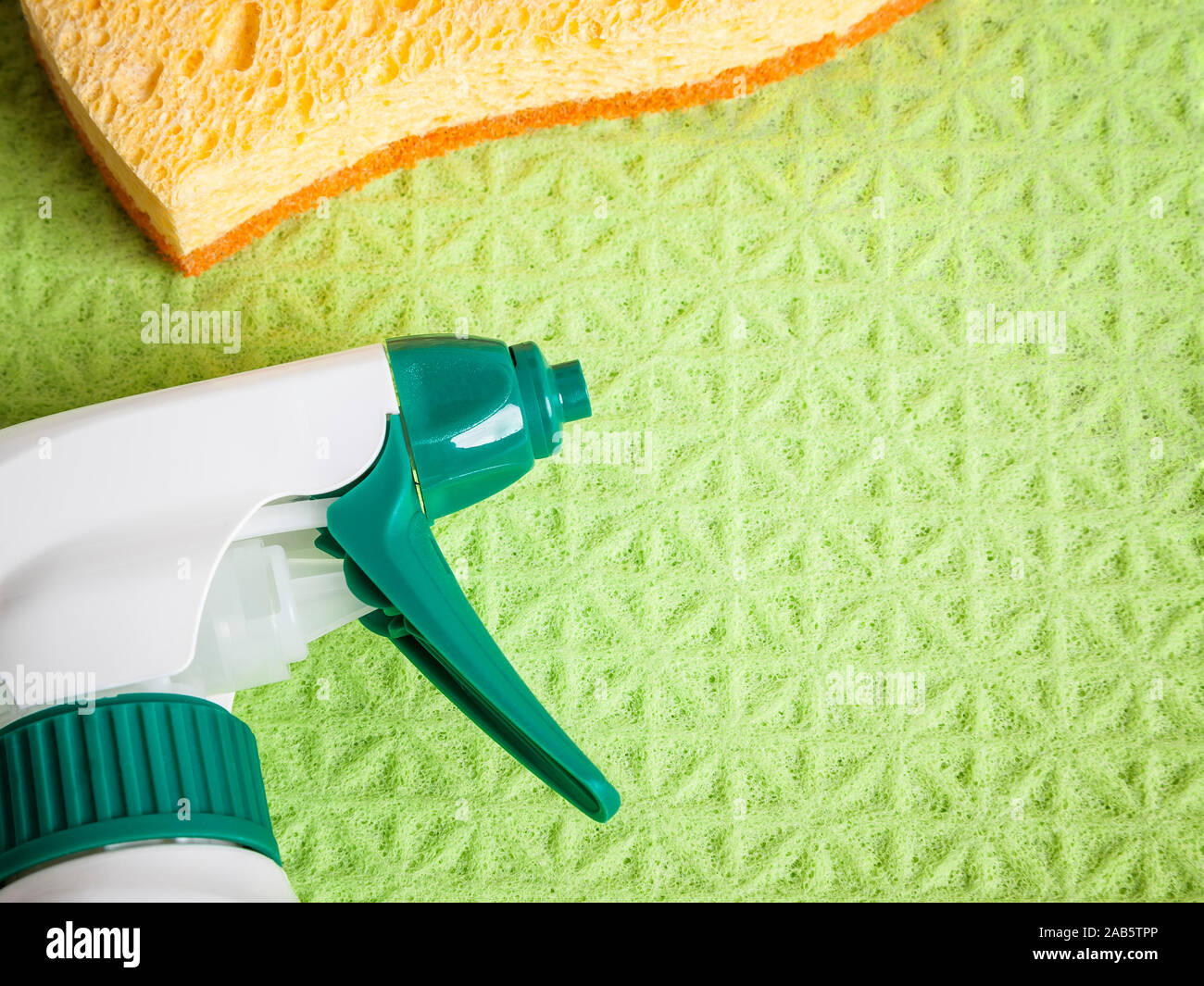 Eine Spruehflasche und ein Schwamm auf einem gruenen Schwammtuch Stock Photo