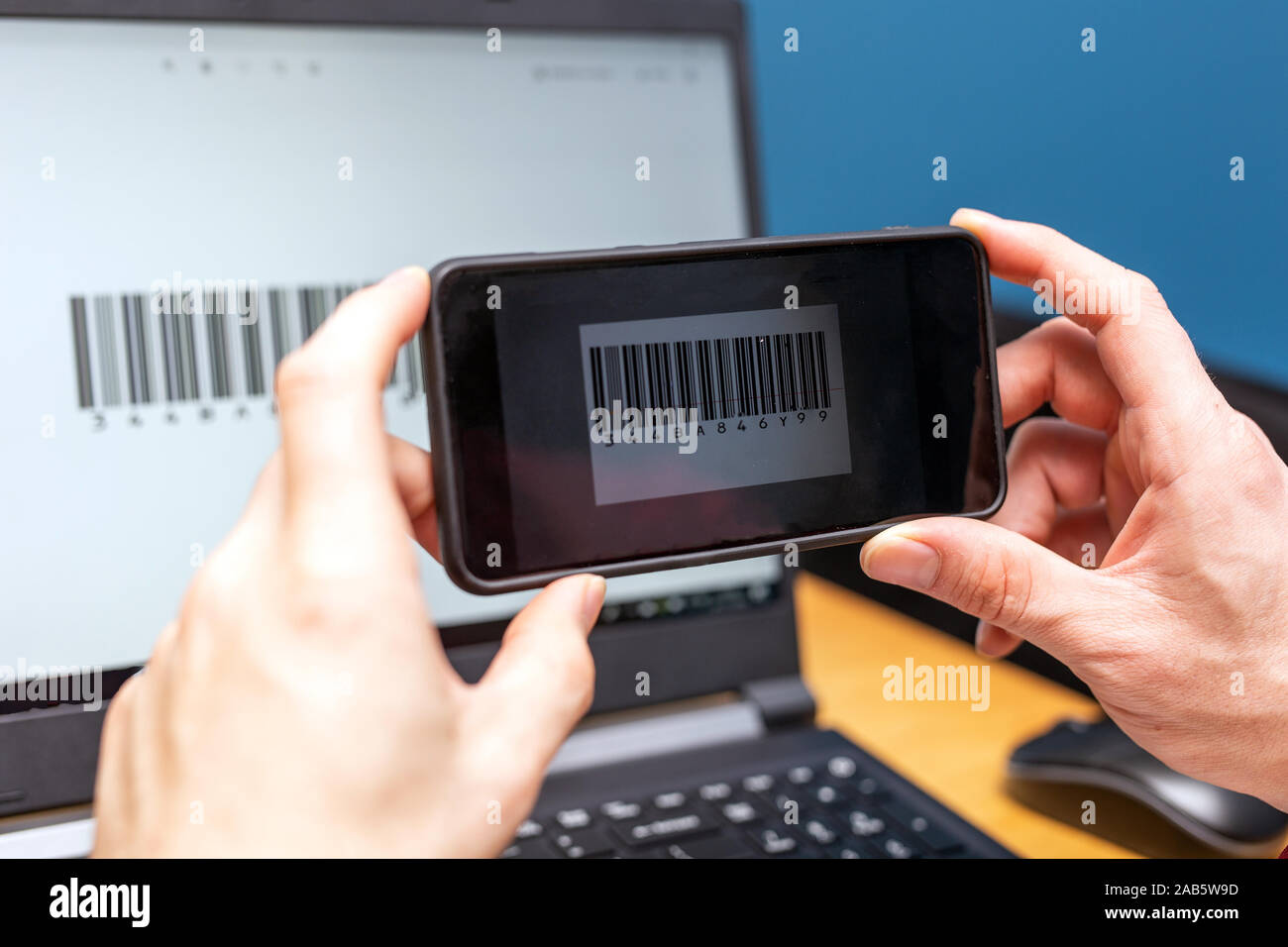 Person scanning with mobile phone, barcode on a computer screen, online