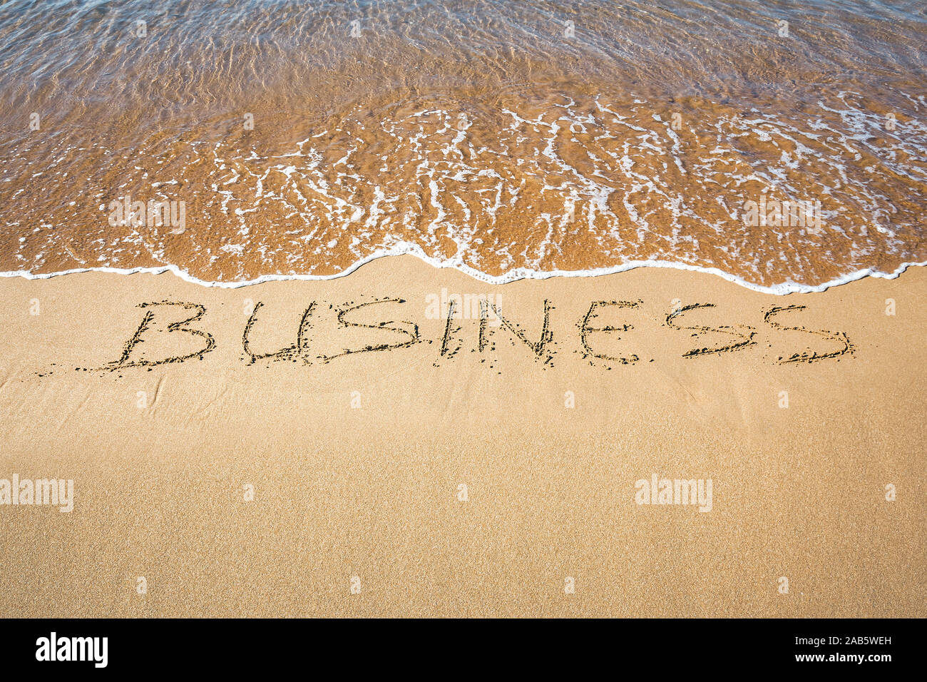 Ein Sandstrand, auf dem 'Business' geschrieben steht. Stock Photo
