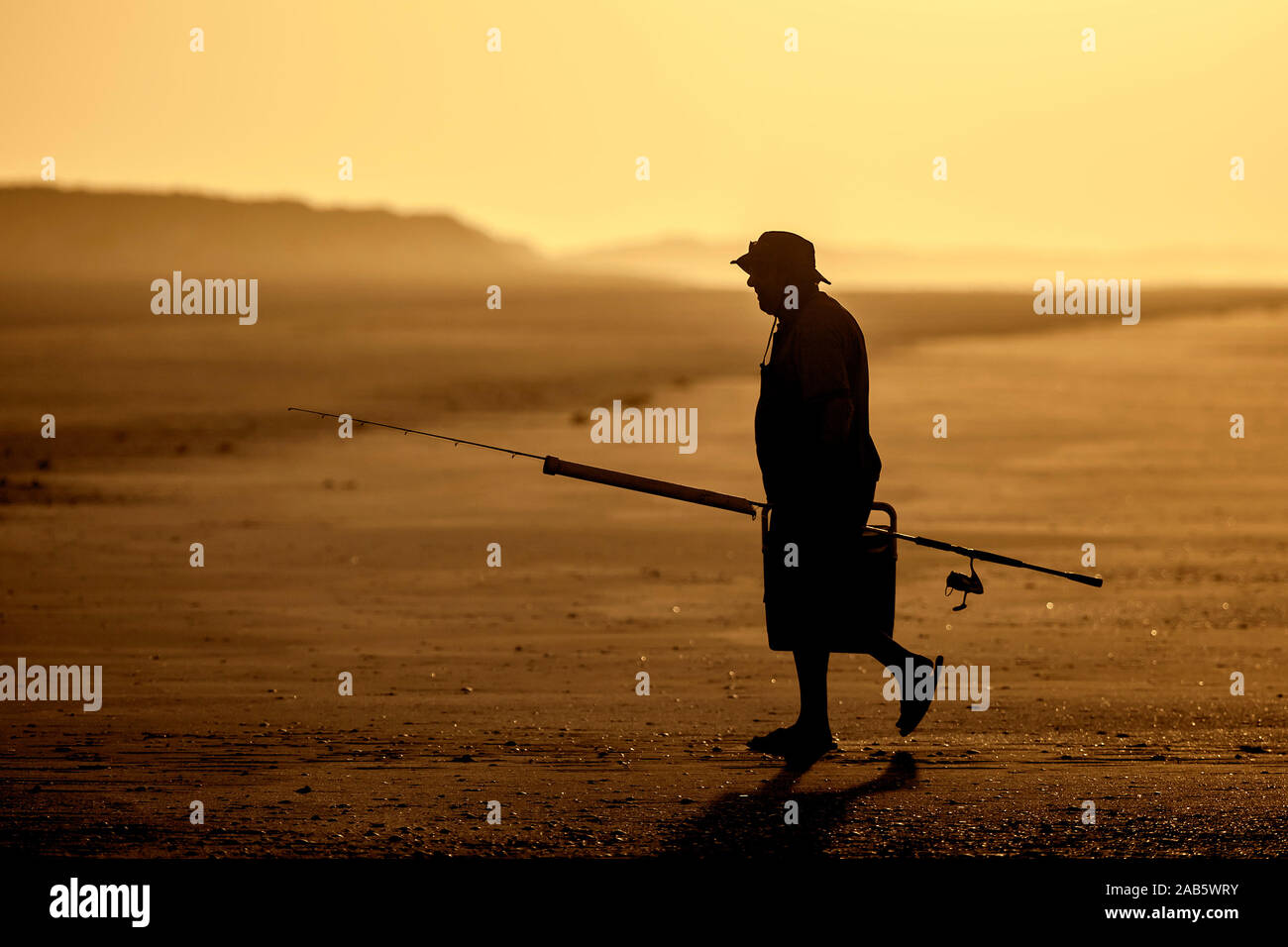 Ein Fischer bei Sonnenuntergang am 80-Meilen-Strand in Australien Stock Photo