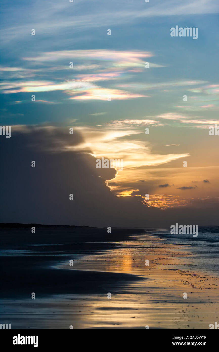 Durch einen Sonnenuntergang in verschiedenes Licht getauchte Wolken ueber dem Ozean Stock Photo