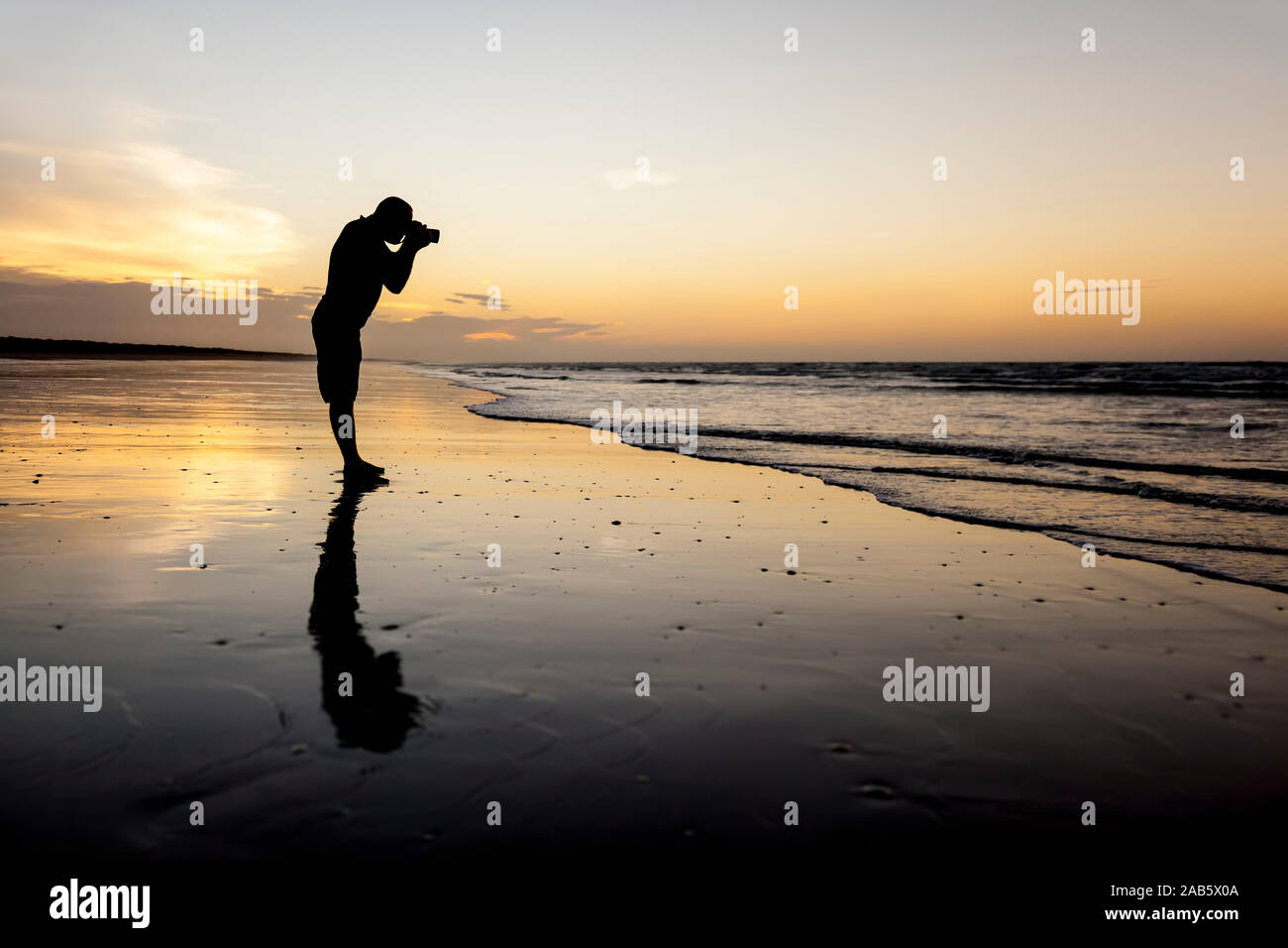 Ein Fotograf bei Sonnenuntergang an einem Strand in Australien Stock Photo