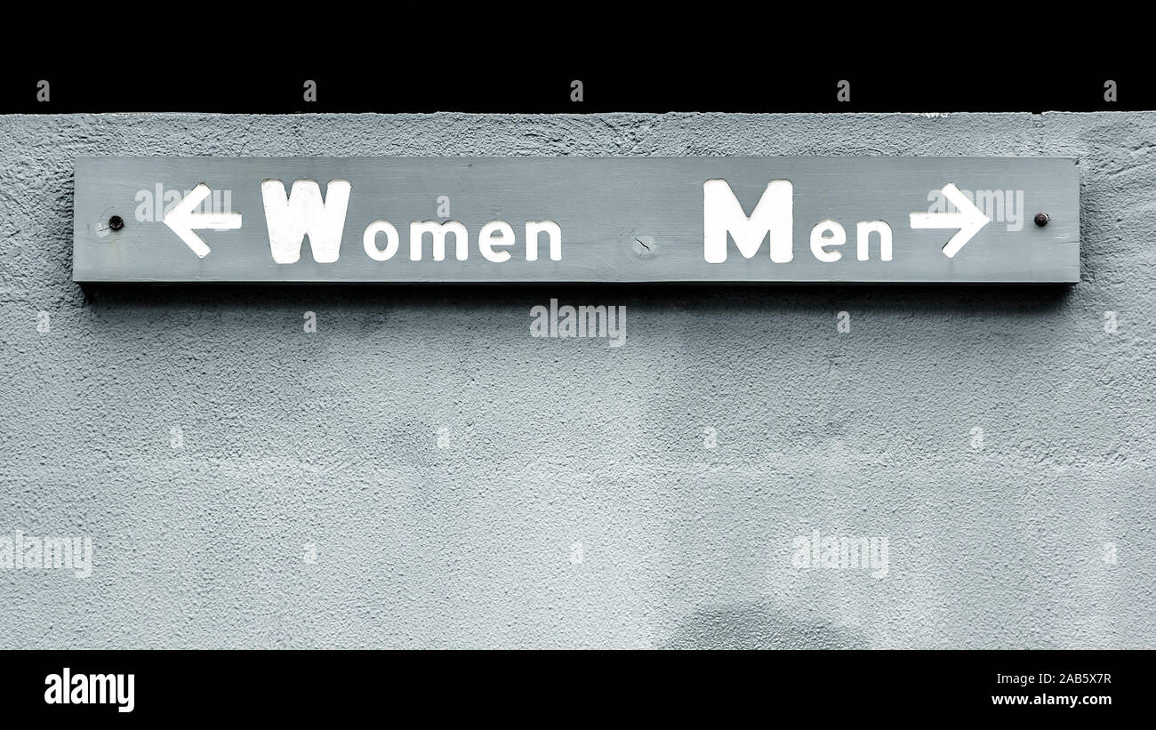 Ein graues Schild, auf dem die Worte 'Women' und 'Men' stehen. Stock Photo