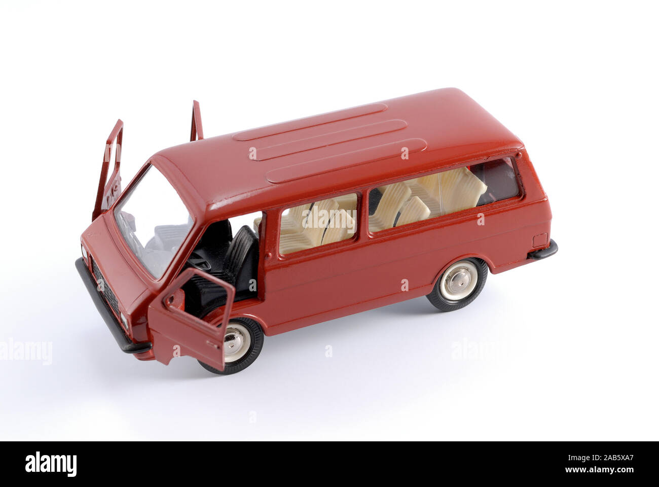 Reduced copy of a red passenger retro minibus car on a white background made of metal Stock Photo