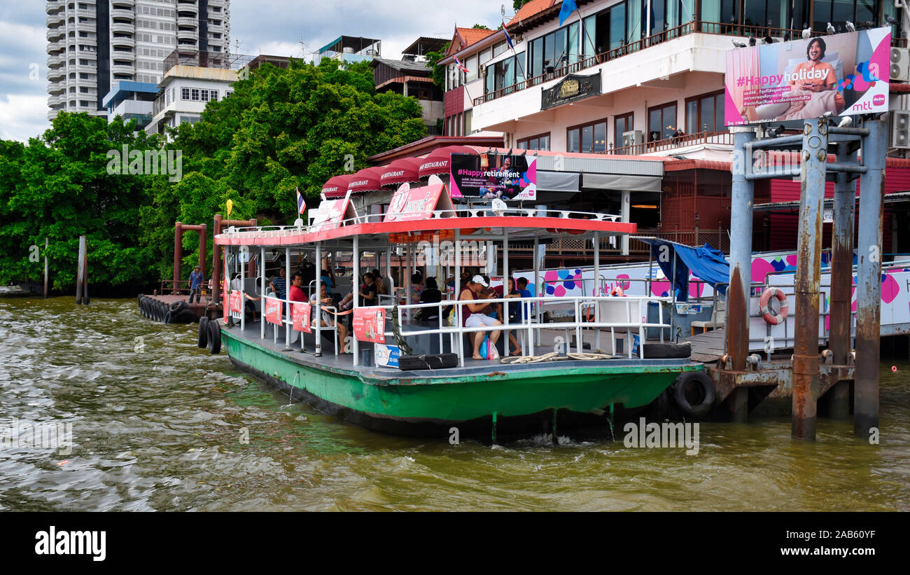 Bangkok, Thailand .11.24.2019: A tourist sightseeing boat with passengers is about to depart from the colorful Chinatown boat station alongside the Ch Stock Photo