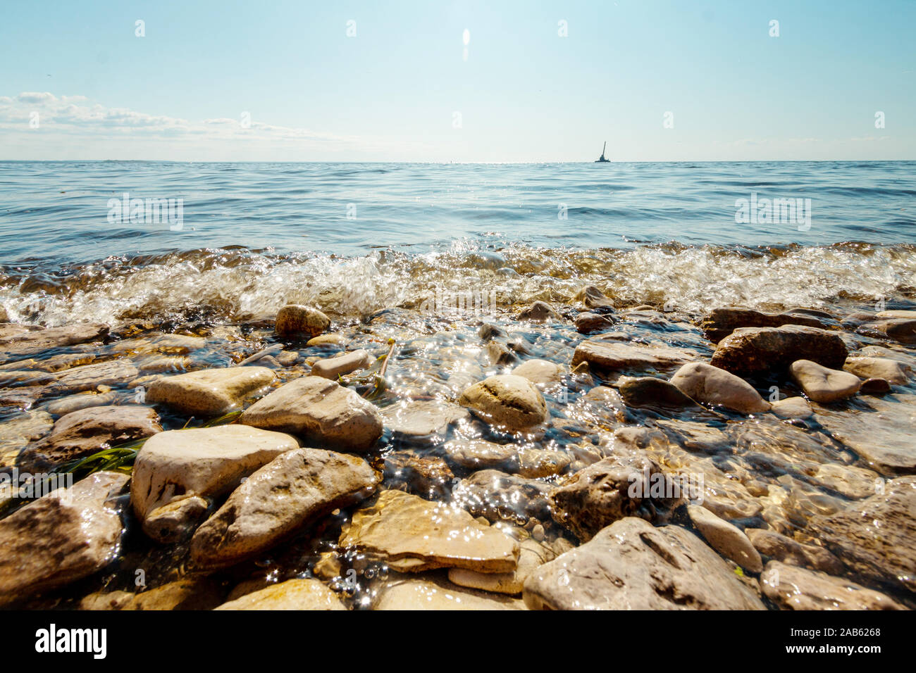 stones on the beach with motion of waves, sunny weather Stock Photo