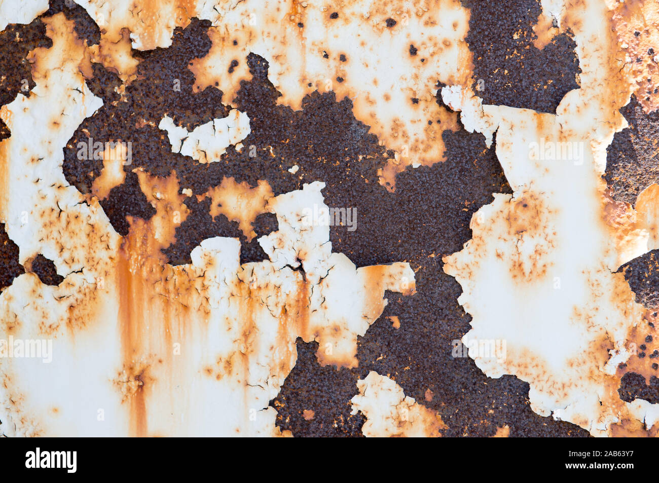 Rust seeping through flaking paint  on metal post Stock Photo