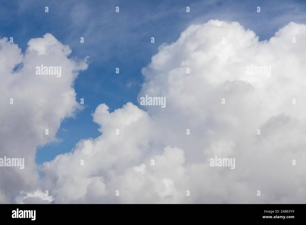 white fluffy cumulus clouds against blue sky Stock Photo