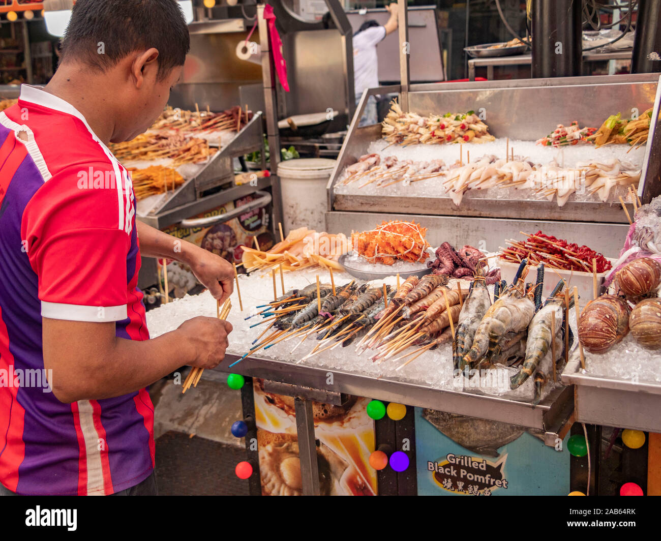 Malaysian man serving on seafood market stall in Bukit Bintang Kuala