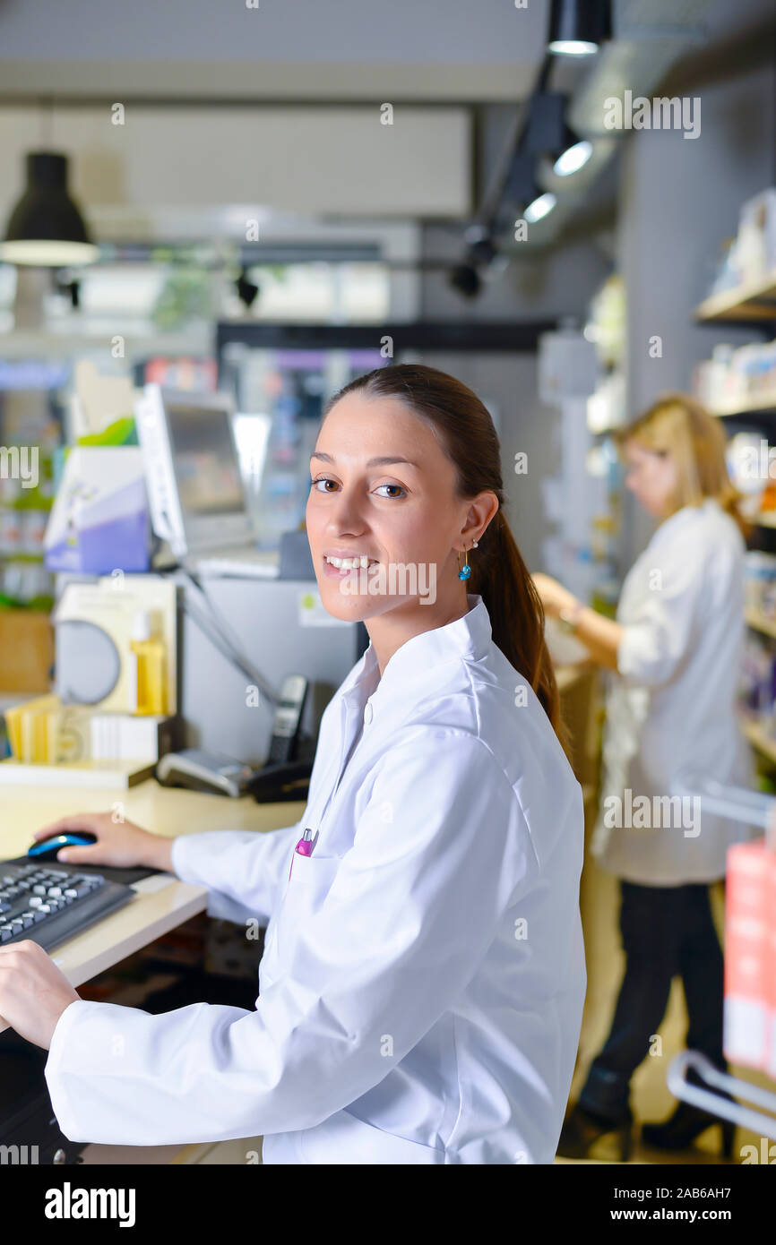 Young female pharmacist working on computer Stock Photo