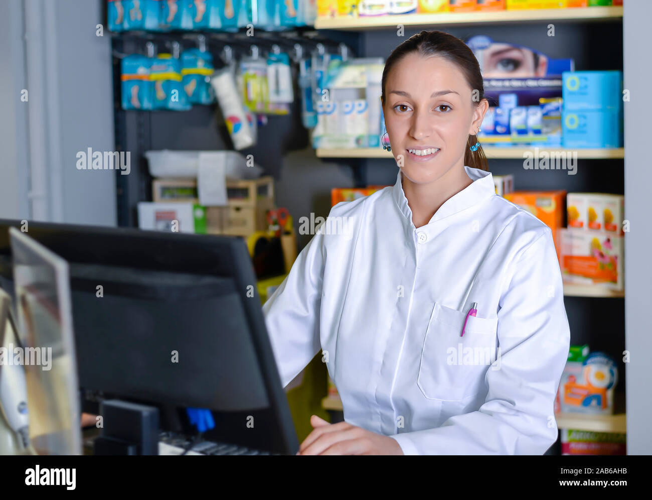 Young female pharmacist working on computer Stock Photo