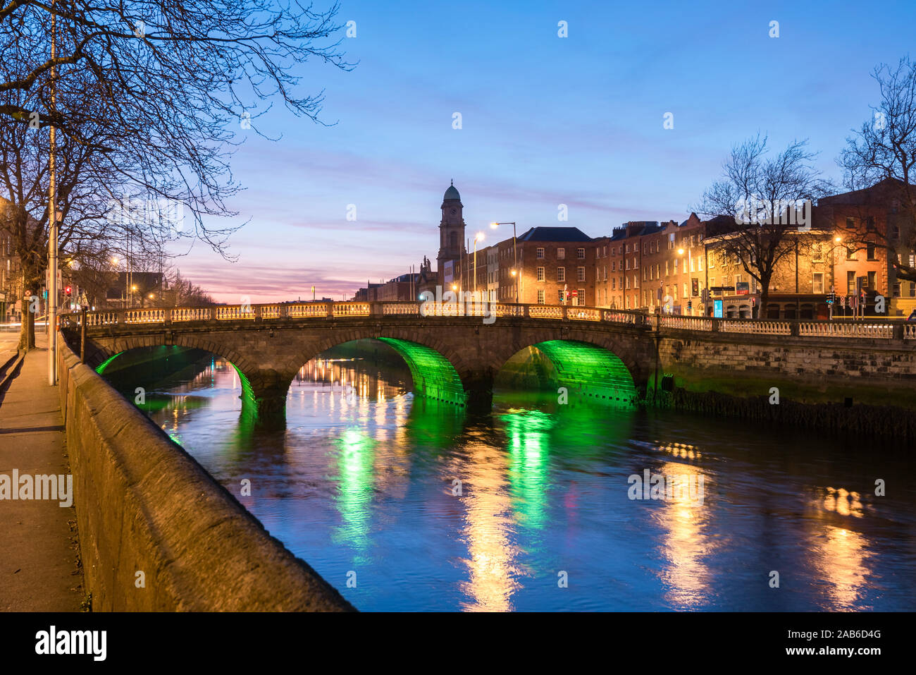 Four Courts and bridge over river Liffey illuminated at night in the city of Dublin in Ireland. Stock Photo