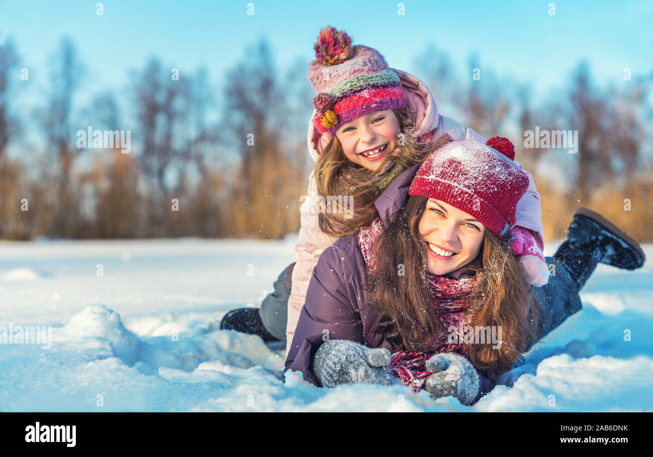 Active mother and daughter playing in winter park Stock Photo