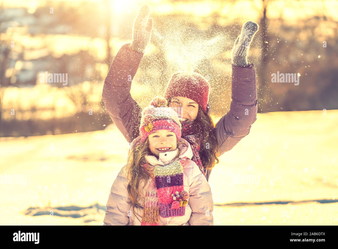 Active mother and daughter playing in winter park Stock Photo