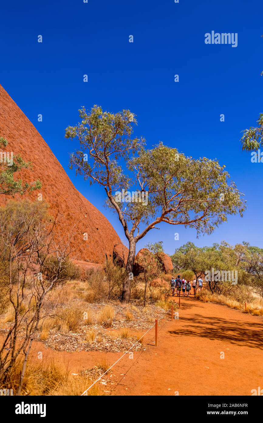 A tourist group along the Mala walk  the base of Uluru (Ayres Rock). Uluru, Northern Territory, Australia Stock Photo