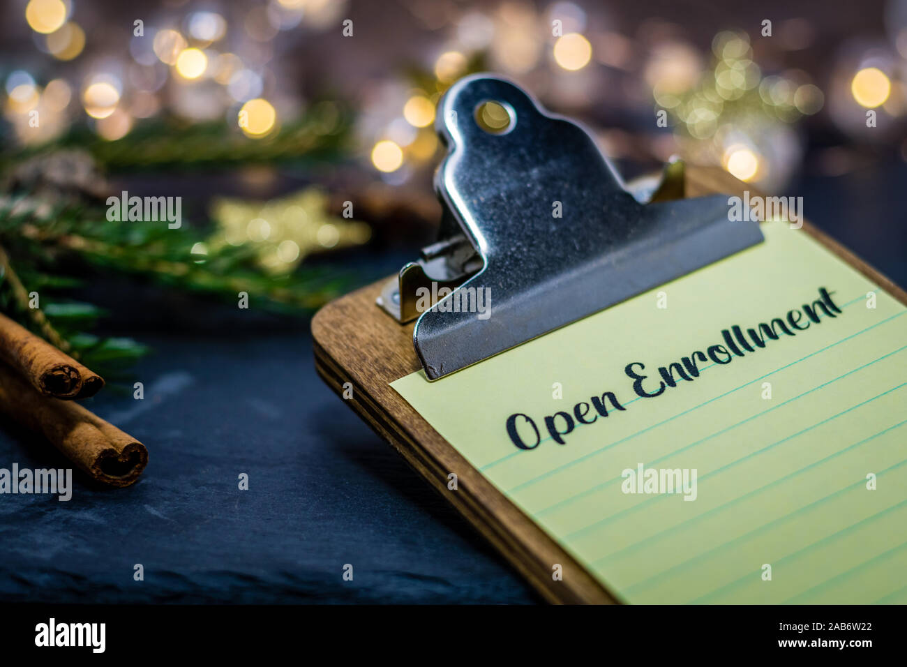 Open Enrollment healthcare choices still life concept on clipboard on dark slate and winter decor Stock Photo