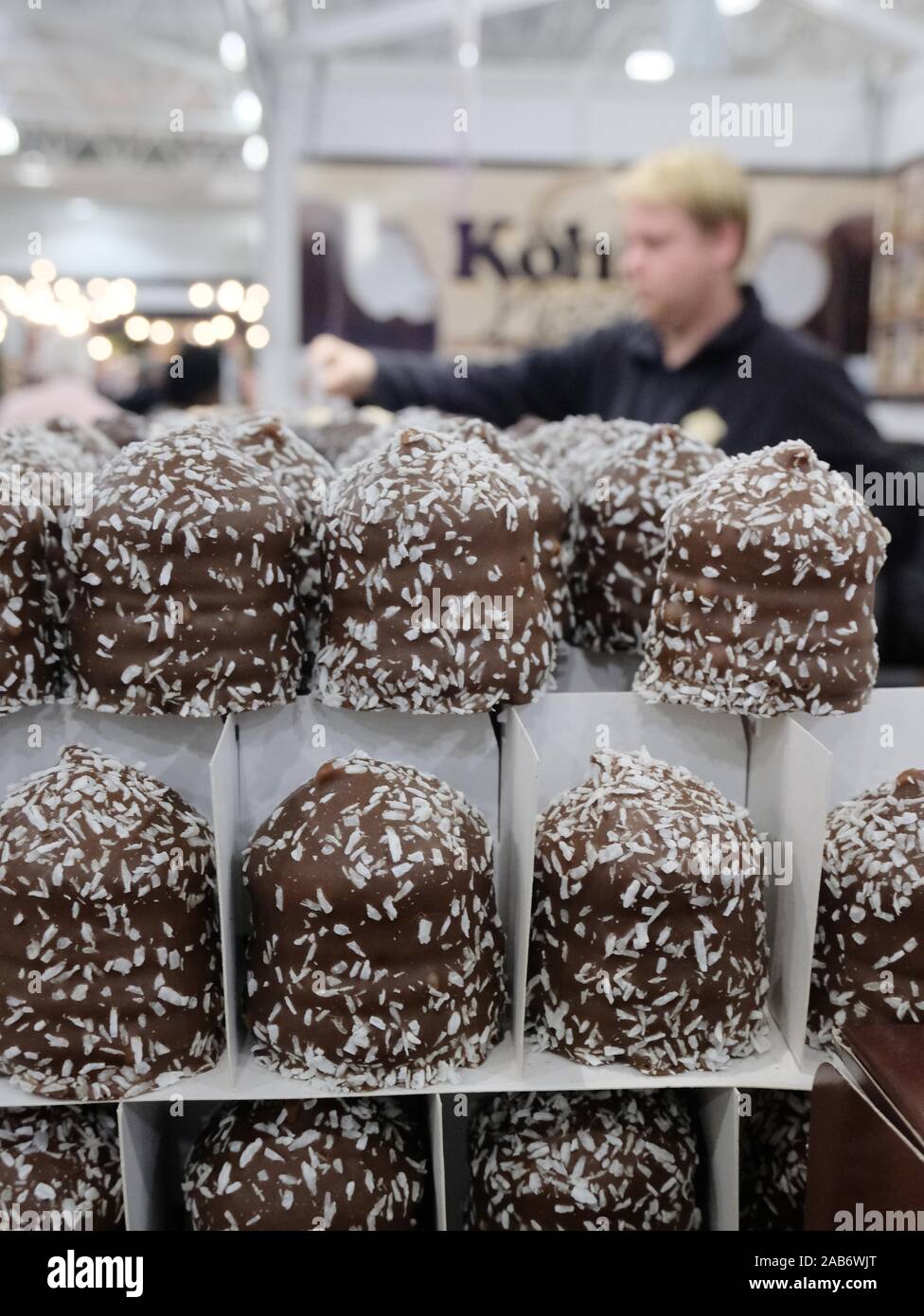 Vendor selling Schaumkuss (chocolate coated marshmallows) at the Ideal Home Christmas Show. Stock Photo