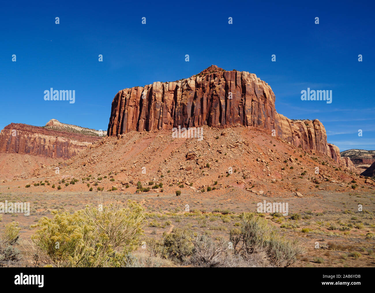 A natural red rock fortress reaches toward the brilliant blue sky in Canyonlands National Park. Stock Photo