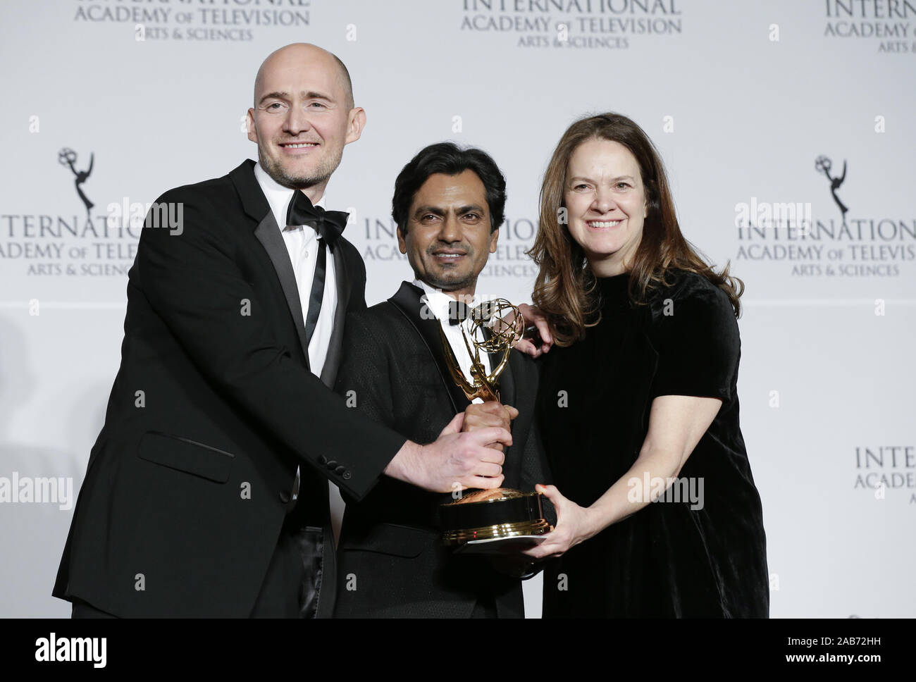 New York, United States. 25th Nov, 2019. British film maker James Watkins (L), Indian actor Nawazuddin Siddiqui and British producer Dixie Linder (R) stand in the press room with the award for "Drama Series" for "McMafia" at the 47th International Emmy Awards at the New York Hilton in New York City on November 25, 2019. Photo by John Angelillo/UPI Credit: UPI/Alamy Live News Stock Photo