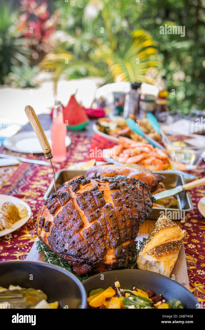 Modern Australian Christmas dinner table with glazed ham, prawns, roast