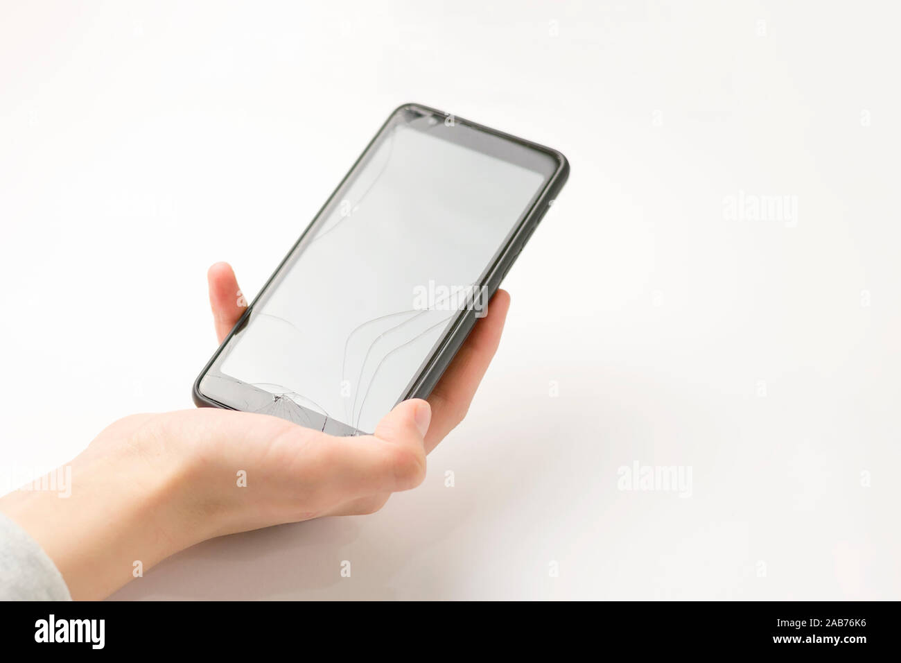 Smartphone in hand on a white background. Broken screen Stock Photo