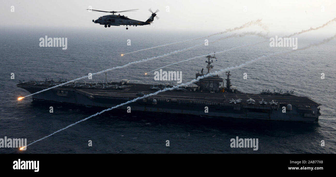 (Feb. 15, 2013) An MH-60R Sea Hawk from the Raptors of Helicopter Maritime Strike Squadron (HSM) 71 launches flares alongside the aircraft carrier USS John C. Stennis (CVN 74). Stock Photo